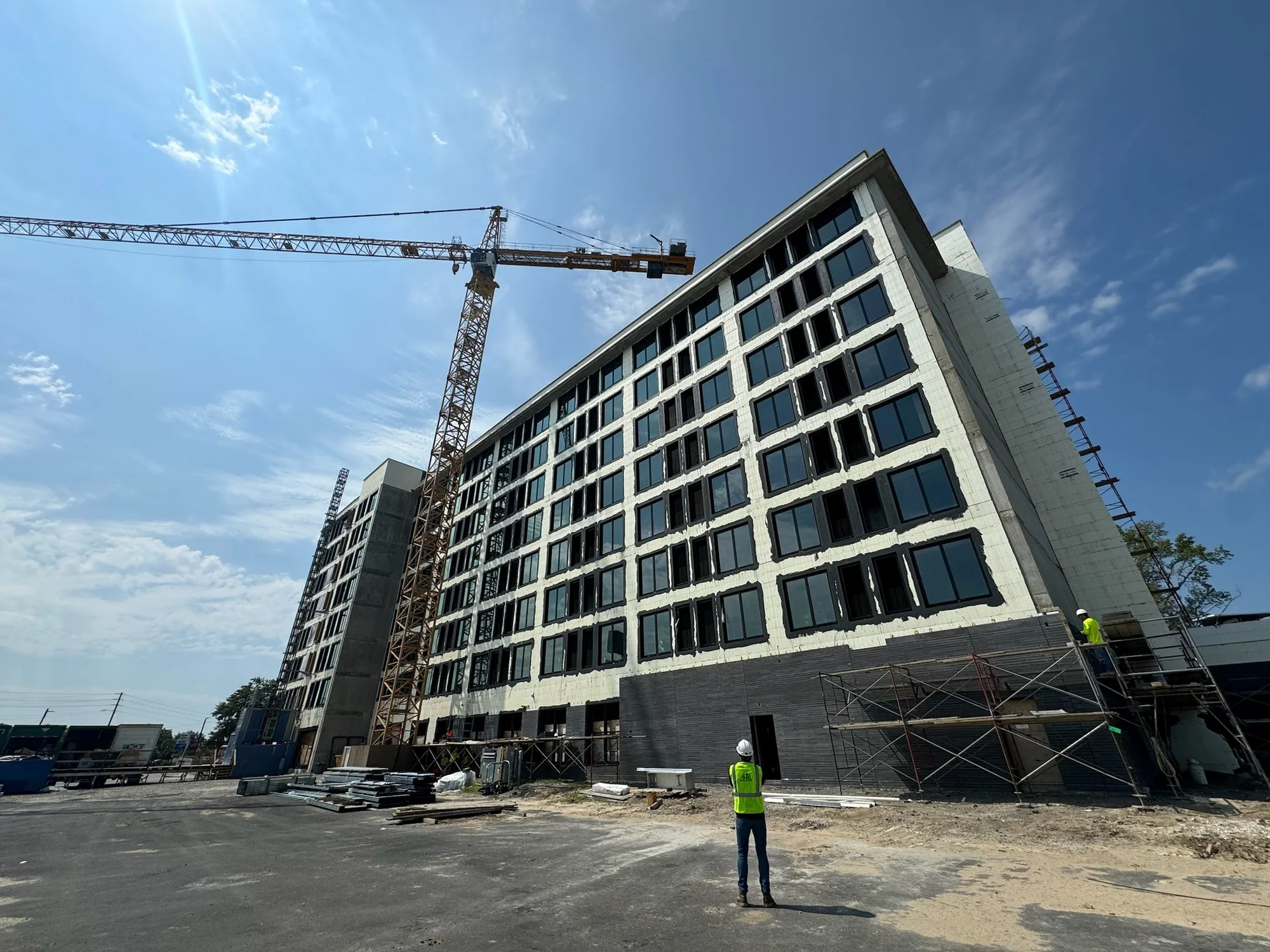 Large multifamily construction project with tower crane and field personnel